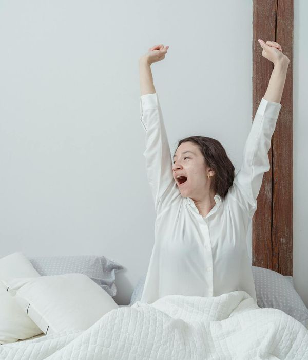 Woman performing a light morning stretch in a calm room.
